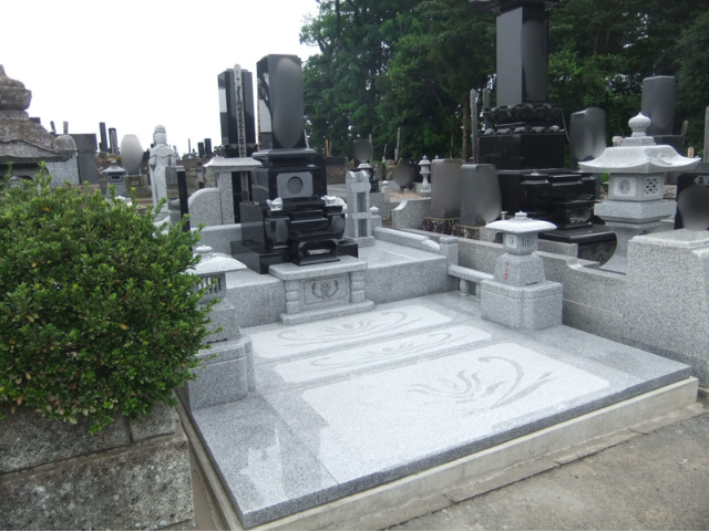 前橋市営丸山霊園に建立された、クンナムと中国産白御影を組み合わせた和型墓石。広い参拝スペースと蓮の模様を施した敷石が特徴の上質な施工例。