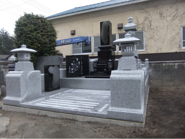 前橋市内の個人墓地に建立された、クンナムと中国産白御影を組み合わせた和型墓石。黒御影の重厚感と白御影の明るさが調和し、参道にストライプ模様を施したデザイン。